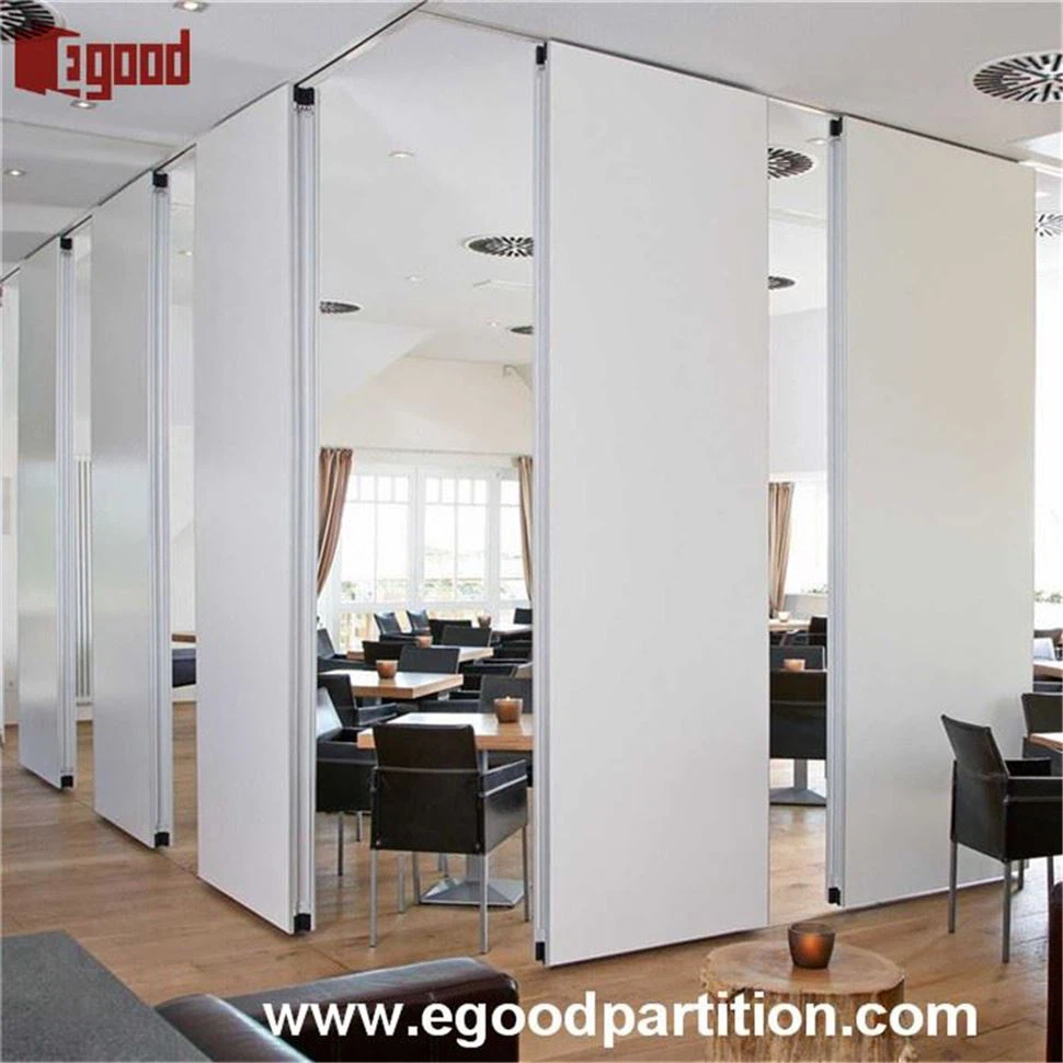 White sliding folding partition wall system separating dining areas in a meeting room, showing flexible space management. White sliding folding partition wall system separating dining areas in a meeting room, showing flexible space management.
